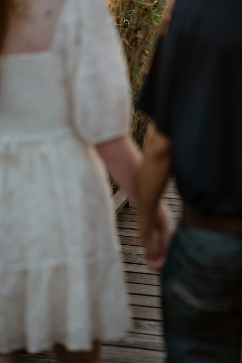 Abby and Collin holding hands on the boardwalk